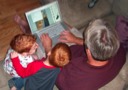 Hayden, Jackson and Dad Looking at Pictures From Bowling